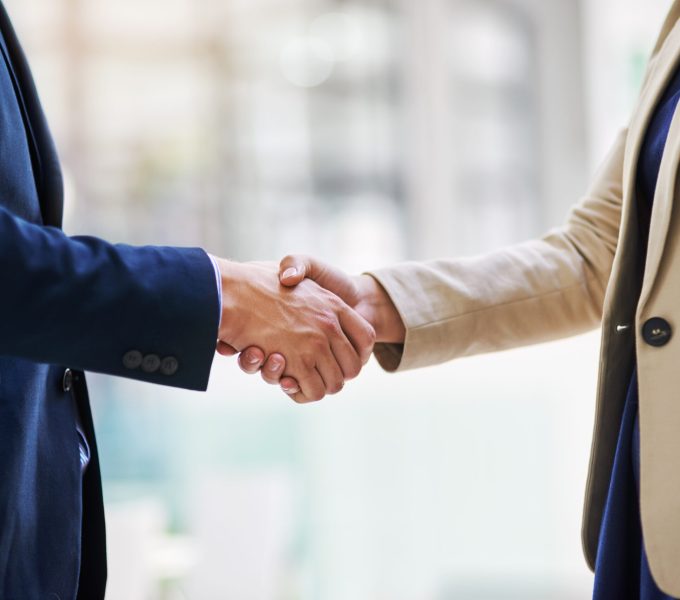 Forging new business associations. Shot of two businesspeople shaking hands